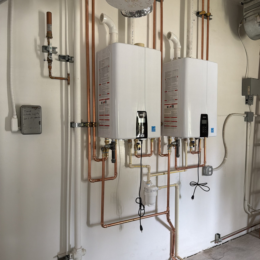 A compact tankless water heater installed on a utility wall.